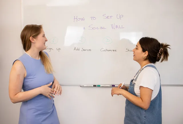 Two women discussing social media wall setup with tips on a whiteboard. A six-state social media training workflow, from intake to exit through synthetic practice