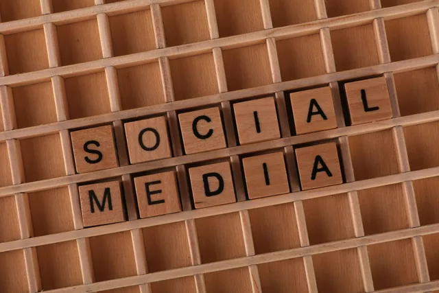 Wooden Scrabble tiles arranged to spell 'Social Media' on a grid background. Social media training selection checklist