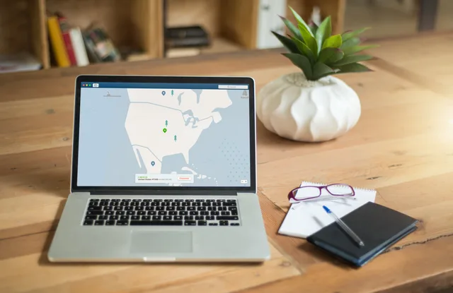 A laptop displaying VPN software sits on a wooden desk with a notepad and plant offering a secure workspace vibe. Social Media Training Tool Implementation: Pre-Launch Tests