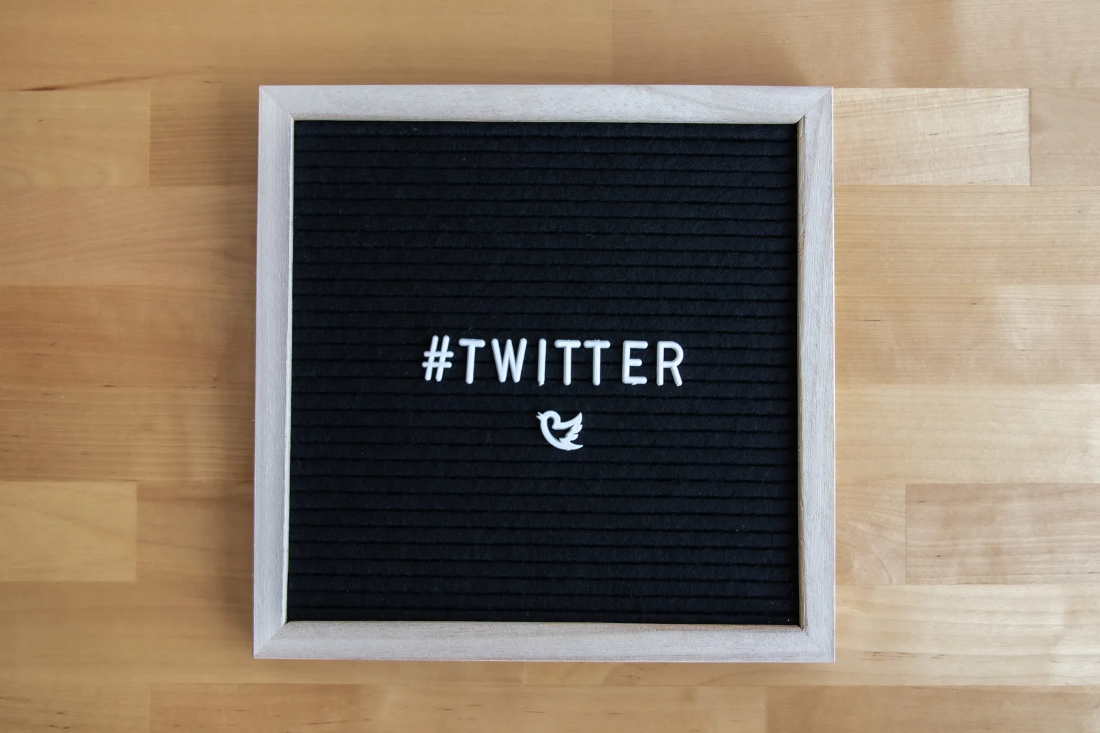 Black letter board with #Twitter hashtag and bird icon, ideal for social media themes.