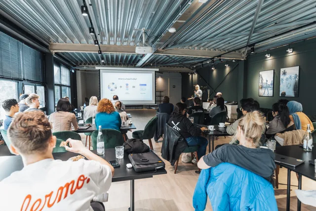 A diverse group attends a corporate presentation in a stylish industrial room, showcasing collaboration. Social media training rules and compliance: adjustments, accounts, assets